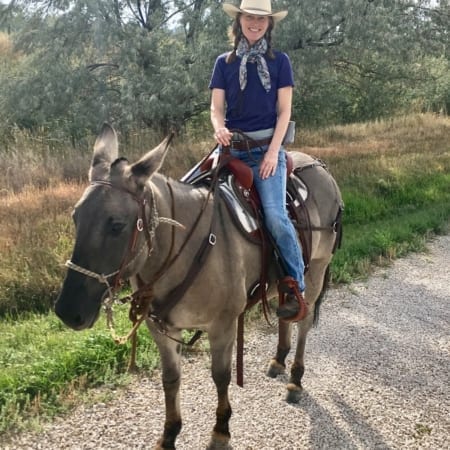 Woman riding mule with high hip using downhill hip saddle pad